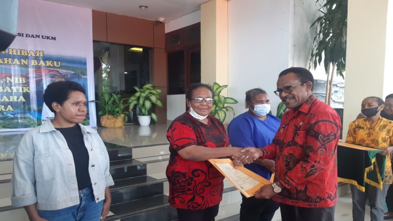 Penjabat Wali Kota Jayapura Frans Pekey (batik merah) saat menyerahkan sertifikat HaKI kepada perajin batik di Kantor Wali Kota Jayapura, Kamis (2/3) (ANTARA/Ardiles Leloltery)