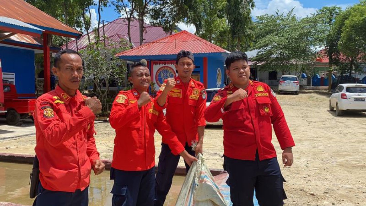 Petugas Damkar saat membawa ular yang telah dimasukkan ke dalam karung. (Antara/La Ode Muh Deden Saputra)