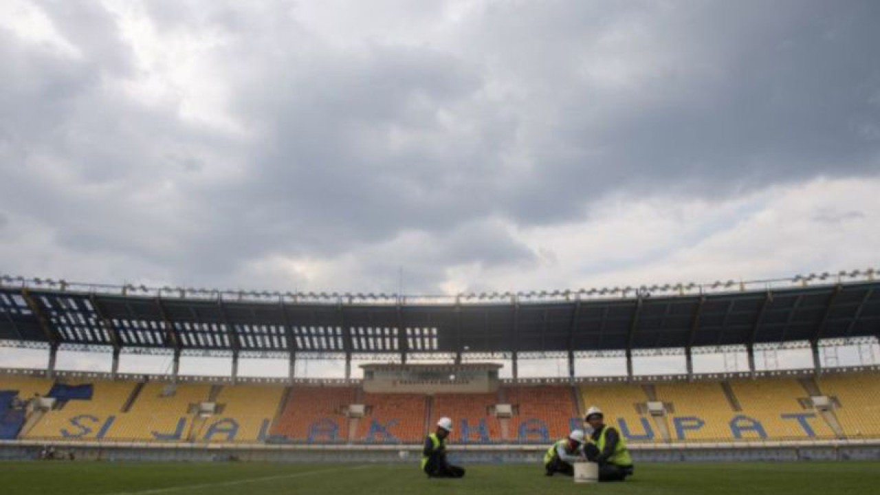 Pekerja merawat rumput lapangan sepak bola saat renovasi Stadion Si Jalak Harupat di Soreang, Kabupaten Bandung, Jawa Barat, Sabtu (11/3/2023). Renovasi Stadion Si Jalak Harupat tersebut ditujukan untuk perhelatan Piala Dunia U-20 pada Mei hingga Juni 2023 mendatang. (ANTARA FOTO/M Agung Rajasa/agr)