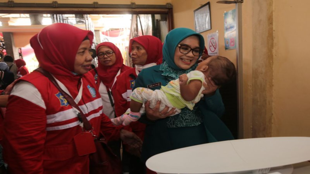 Ketua TP PKK Surabaya Rini Indriyani menggendong balita saat berkunjung di salah satu puskesmas di Kota Surabaya. (ANTARA/HO-Diskominfo Surabaya)
