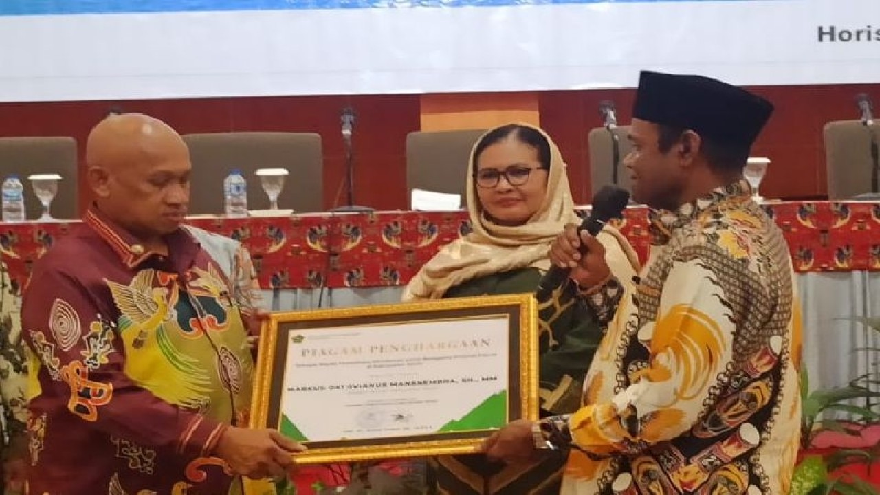 Penyerahan penghargaan oleh Plt Kakanwil Kemenag Papua Klemens Taran kepada Bupati Sarmi Markus Oktovianus Mansnembra pada salah satu hotel di Kota Jayapura, Papua, Jumat (24/3). (ANTARA/ HO - Humas Pemkab Sarmi)