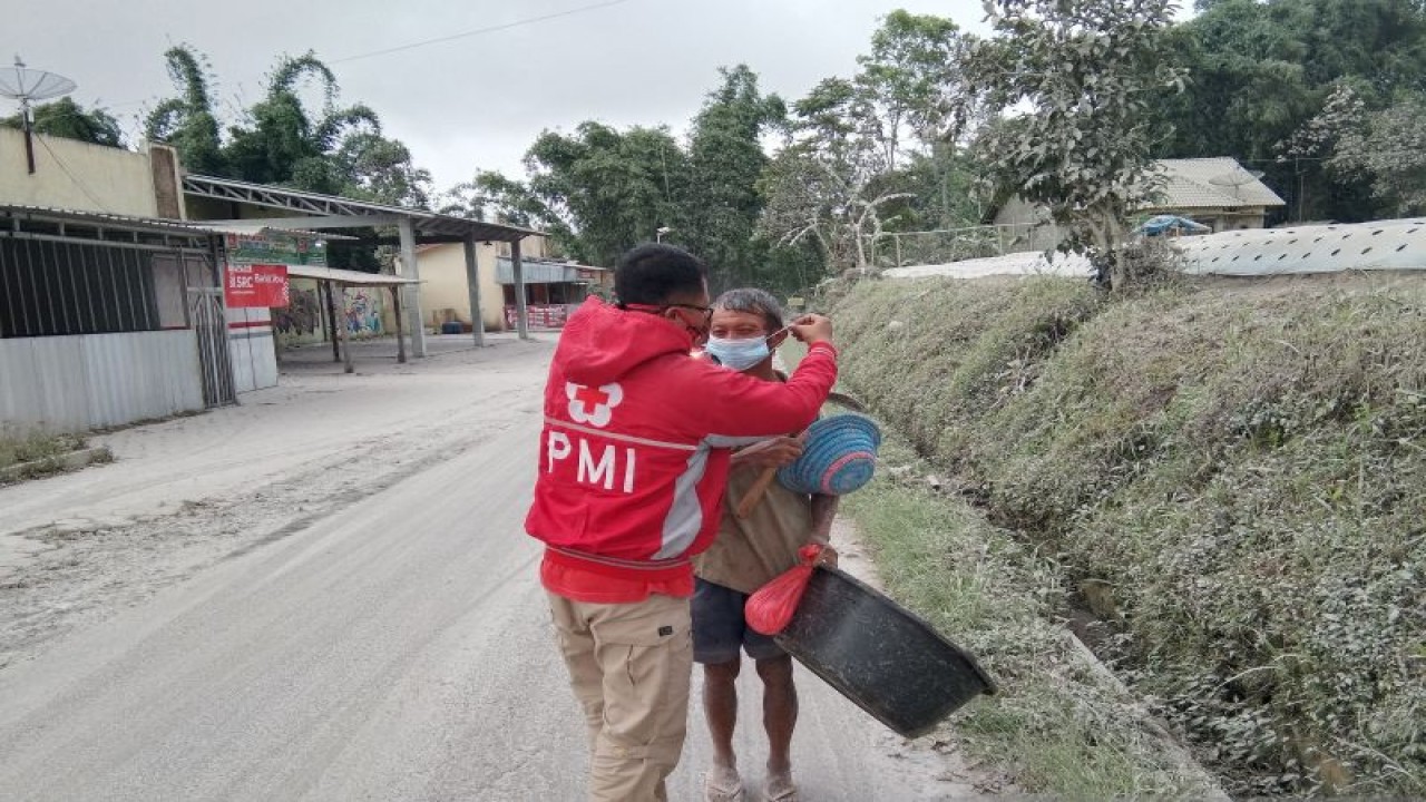 Relawan PMI sedang membantu memasangkan masker kepada seorang lansia yang berada di daerah terdampak bencana erupsi Gunung Merapi di Kabupaten Magelang, Jateng. Antara/HO/Humas PMI Pusat