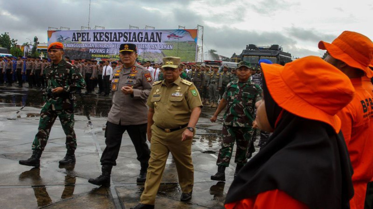 Wakil Gubernur Riau Edy Natar Nasution (tengah) bersama Kepala Polda Riau Irjen Pol Mohammad Iqbal (kedua kiri) memeriksa barisan saat Apel Kesiapsiagaan Penanggulangan Bencana Kebakaran Hutan dan Lahan Provinsi Riau Tahun 2023 di halaman Kantor Gubernur Riau di Kota Pekanbaru, Selasa (21/3/2023). (ANTARA FOTO/Rony Muharrman/aww)