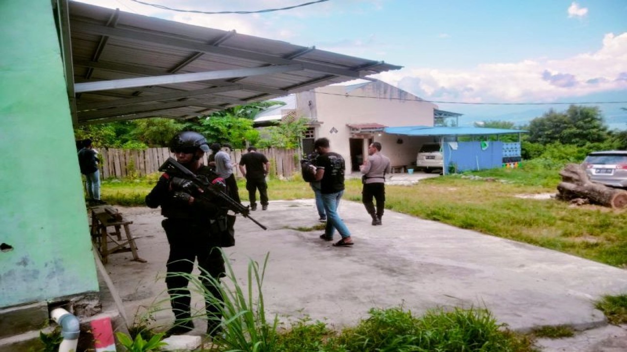 Salah satu Anggota Densus 88 bersenjata lengkap berdiri di rumah yang digeledah di Provinsi Sulawesi Tengah, Kamis (16/3/2023). (ANTARA/HO)