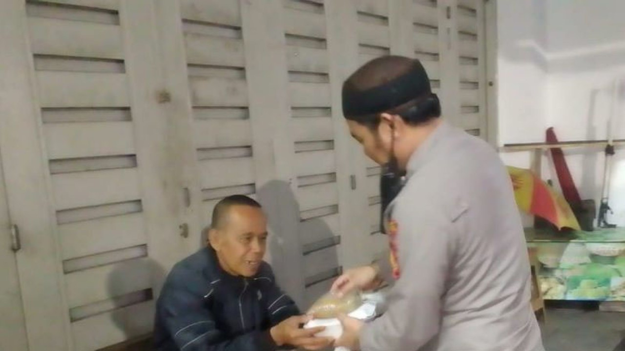 Personel Polsek Warudoyong Resor Sukabumi Kota tengah memberikan paket sembako kepada warga di Kecamatan Warudoyong, Kota Sukabumi, Jabar di sela kegiatan patroli. Antara/Aditya Rohman