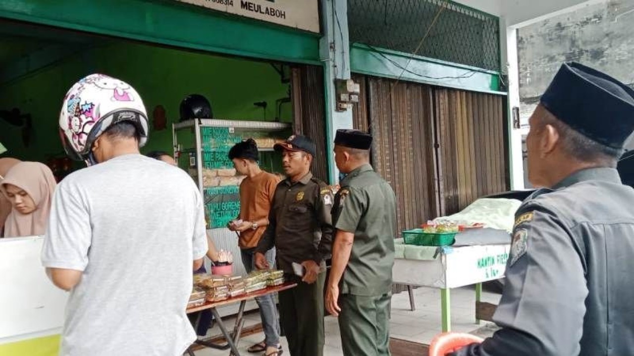 Petugas Wilayatul Hisbah (WH) menegur pedagang yang menjual makanan di siang hari saat bulan suci Ramadhan 1444 Hijriyah, di ruas Jalan Merdeka, Meulaboh, karena melanggar ketentuan syariat Islam dan meminta toko tersebut ditutup, Sabtu (25/3/2023). (ANTARA/HO-Dok Satpol PP WH Aceh Barat)