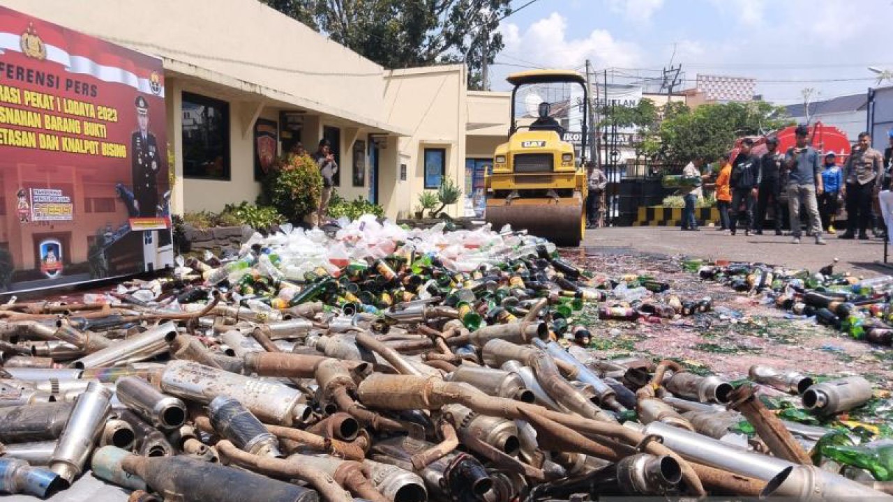 Ribuan botol minuman keras berbagai merek dan ratusan knalpot bising dimusnahkan di halaman Polres Cianjur, Jawa Barat, mengunakan alat berat, Selasa (21/3/2023). ANTARA/Ahmad Fikri.