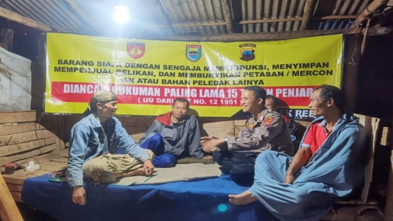 Seorang anggota Polres Batang sedang menyosialisasikan dan pemasangan spanduk larangan menyalakan petasan di pos kamling bersama warga, Jumat (31/3/2023). ANTARA/HO-Humas Kabupaten Batang