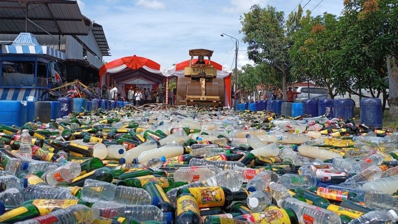Petugas memusnahkan minuman keras dengan cara dilindas menggunakan alat berat di Indramayu, Jawa Barat, Jumat (24/3/2023). (ANTARA/Khaerul Izan)