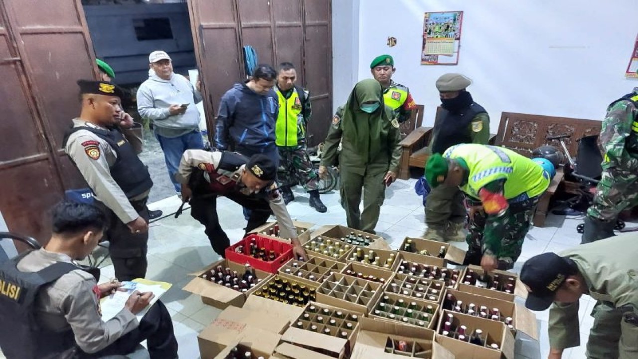 Aparat Polres Kudus bersama tim gabungan mendata jumlah minuman keras hasil sitaan di salah satu tempat penyimpanan di Desa Tanjung Karang, Kecamatan Jati, Kabupaten Kudus, Jawa Tengah. (ANTARA/HO-Polisi Kudus.)