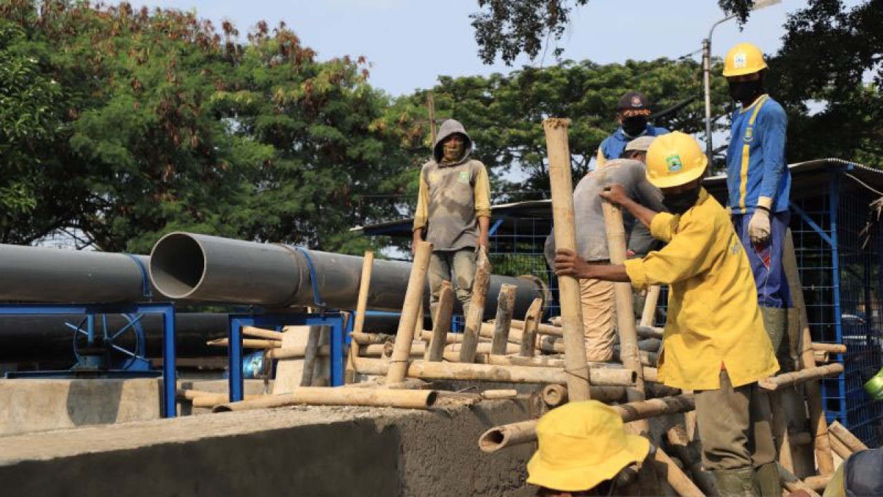 Petugas PUPR Kota Tangerang sedang melakukan pemasangan pompa penyedot air.