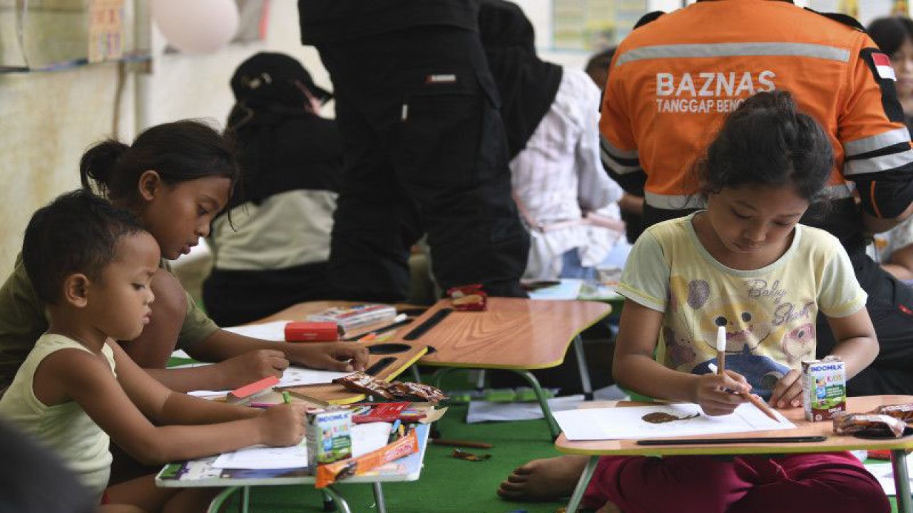 Relawan mendampingi sejumlah anak mewarnai gambar saat sesi trauma healing di RPTRA Rasela, Rawa Badak, Jakarta Utara, Minggu (5/3/2023). ANTARA FOTO/M Risyal Hidayat/nym.
