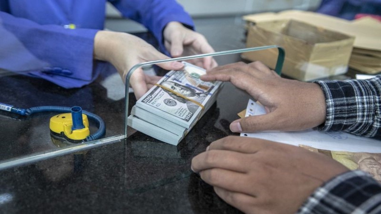 Petugas memberikan uang pecahan dolar AS kepada pembeli di gerai penukaran mata uang asing VIP (Valuta Inti Prima) Money Changer, Jakarta, Selasa (4/10/2022). ANTARA FOTO/Muhammad Adimaja/aww.