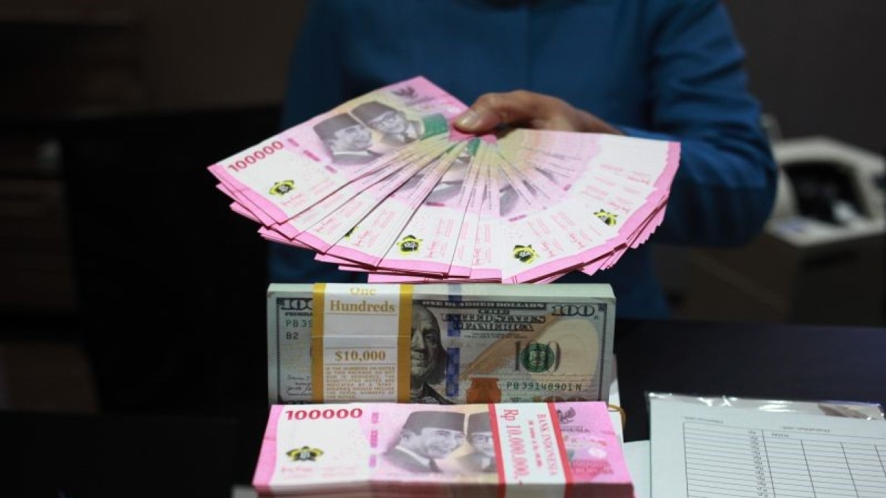 Petugas menunjukkan uang dolar AS dan uang rupiah di salah satu kantor cabang PT. Bank Mandiri Persero Tbk, Jakarta, Selasa (31/1/2023). Nilai tukar (kurs) rupiah yang ditransaksikan antarbank di Jakarta merosot 33 poin atau 0,22 persen ke posisi Rp15.003 per dolar AS dibandingkan posisi pada penutupan perdagangan sebelumnya Rp14.970 per dolar AS. ANTARA FOTO/Reno Esnir/tom (ANTARA FOTO/RENO ESNIR)