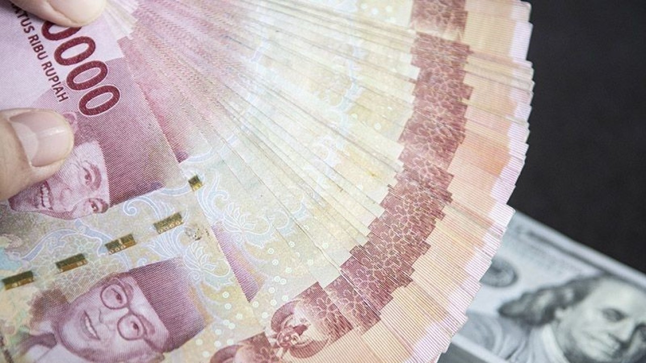 Ilustrasi - Petugas menunjukan uang pecahan rupiah dan dolar AS di gerai penukaran mata uang asing VIP (Valuta Inti Prima) Money Changer, Jakarta. (ANTARA FOTO/Muhammad Adimaja/foc/pri.)