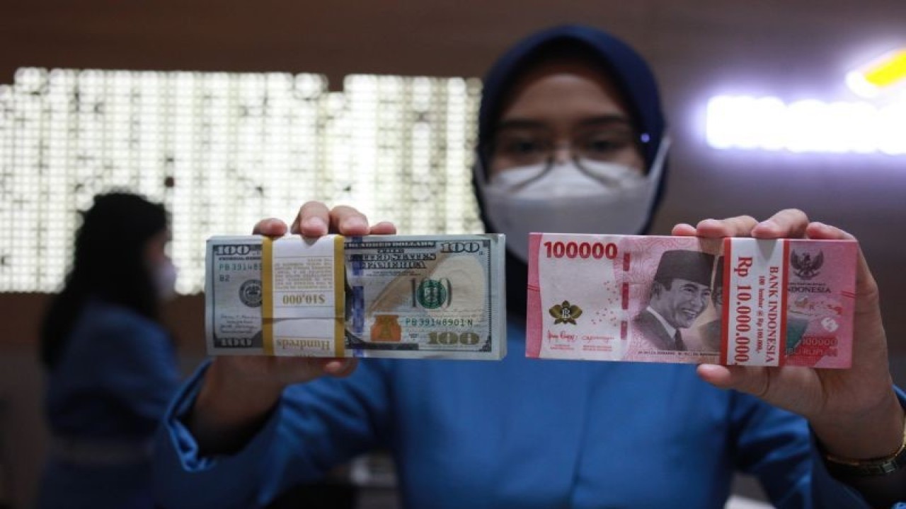 Petugas menunjukkan uang dolar AS dan uang rupiah di salah satu kantor cabang Bank Mandiri Persero Tbk, Jakarta, Selasa (31/1/2023). ANTARA FOTO/Reno Esnir/tom.
