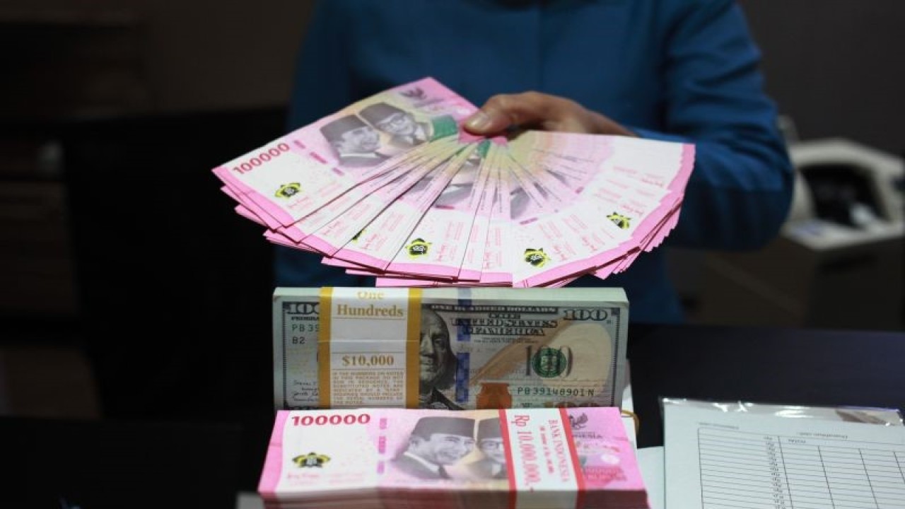Petugas menunjukkan uang dolar AS dan uang rupiah di salah satu kantor cabang PT. Bank Mandiri Persero Tbk, Jakarta, Selasa (31/1/2023). Nilai tukar (kurs) rupiah yang ditransaksikan antarbank di Jakarta merosot 33 poin atau 0,22 persen ke posisi Rp15.003 per dolar AS dibandingkan posisi pada penutupan perdagangan sebelumnya Rp14.970 per dolar AS. ANTARA FOTO/Reno Esnir/tom (ANTARA FOTO/RENO ESNIR)