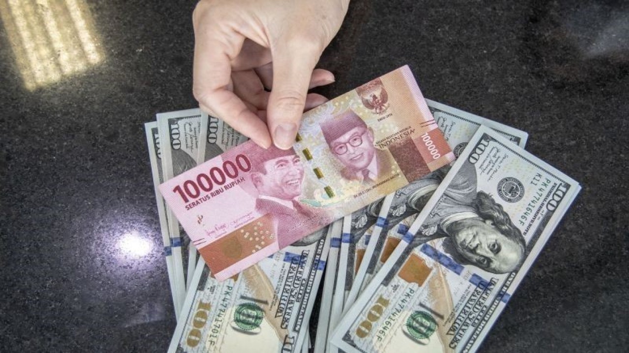 Petugas menunjukan uang pecahan rupiah dan dolar AS di gerai penukaran mata uang asing VIP (Valuta Inti Prima) Money Changer, Jakarta, Selasa (4/10/2022). ANTARA FOTO/Muhammad Adimaja/aww.