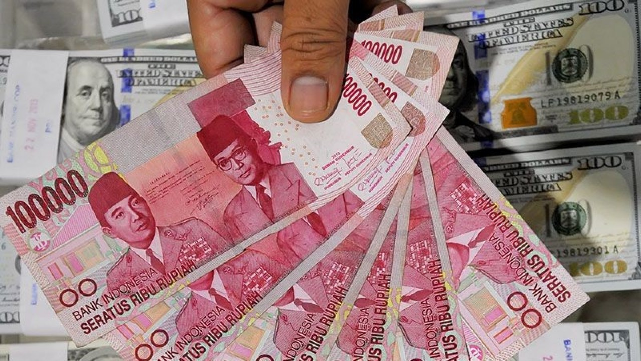 Petugas menunjukan uang kertas pecahan Rp100ribu di Cash Center Bank Mandiri, Jakarta. ANTARA FOTO/Yudhi Mahatma/ed/pd/pri.