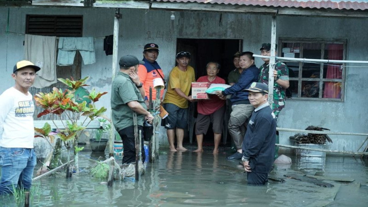 Bupati Sambas Satono menyerahkan bantuan kepada warga yang terdampak banjir di Kecamatan Jawai, Kabupaten Sambas, Provinsi Kalimantan Barat. (ANTARA/Imbran)