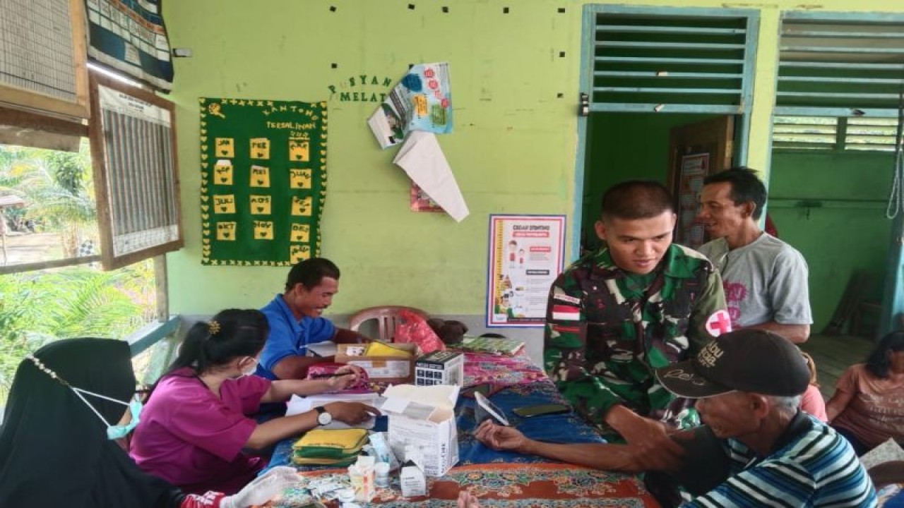 Petugas kesehatan Puskesmas Badau bersama prajurit Satgas Pamtas Yonarmed Trk Bogani memberikan pelayanan kesehatan kepada masyarakat dalam program Pos pembinaan terpadu (Posbindu) yang dilaksanakan di Desa Seriang Kecamatan Badau perbatasan Indonesia-Malaysia, wilayah Kabupaten Kapuas Hulu Provinsi Kalimantan Barat. ANTARA/HO-Yonarmed Trk Bogani. (Teofilusianto Timotius)