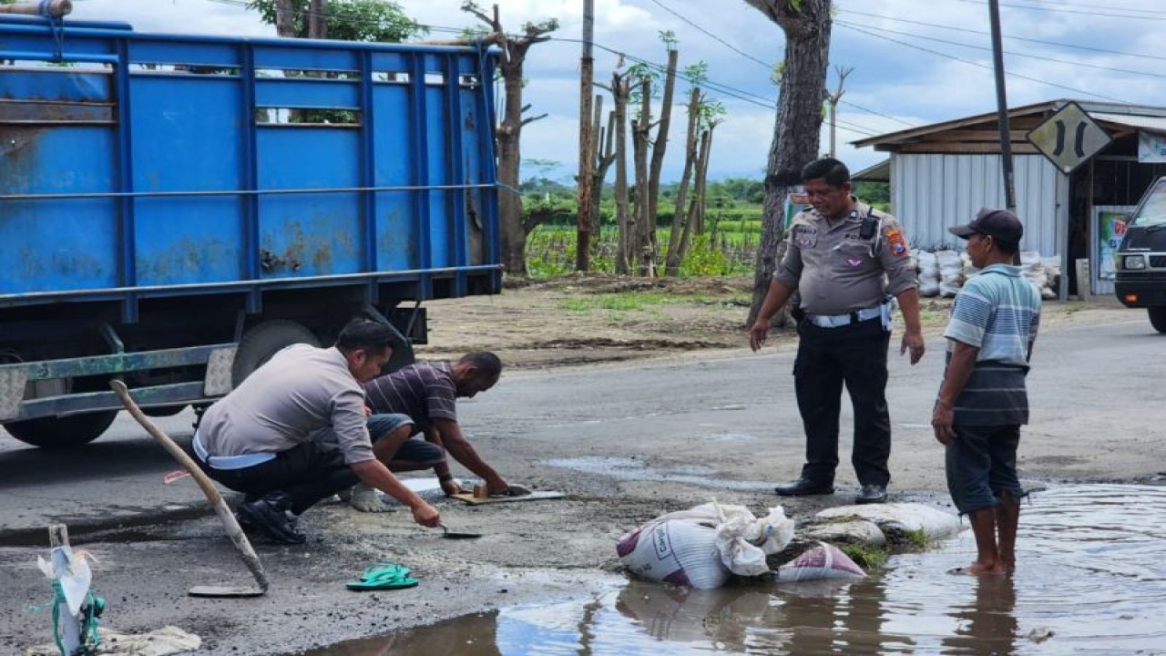 Aparat Satuan Lalu Lintas Polres Blitar Kota, turun tangan melakukan penambalan jalan rusak di area Kecamatan Srengat, Kabupaten Blitar, Jawa Timur, Rabu (1/3/2023). Kegiatan ini dilakukan sebagai upaya mengurangi tingkat fatalitas kecelakaan. ANTARA/ HO-Polres Blitar Kota