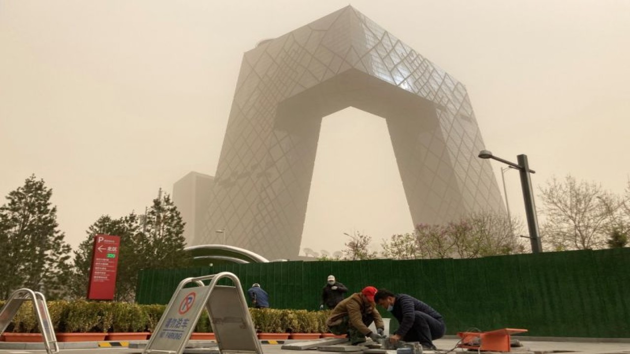 Arsip - Pekerja konstruksi terlihat di depan kantor pusat CCTV terselubung debu saat kota terkena badai pasir di Beijing, China, Minggu (28/3/2021). ANTARA FOTO/REUTERS/Martin Pollard/WSJ/cfo