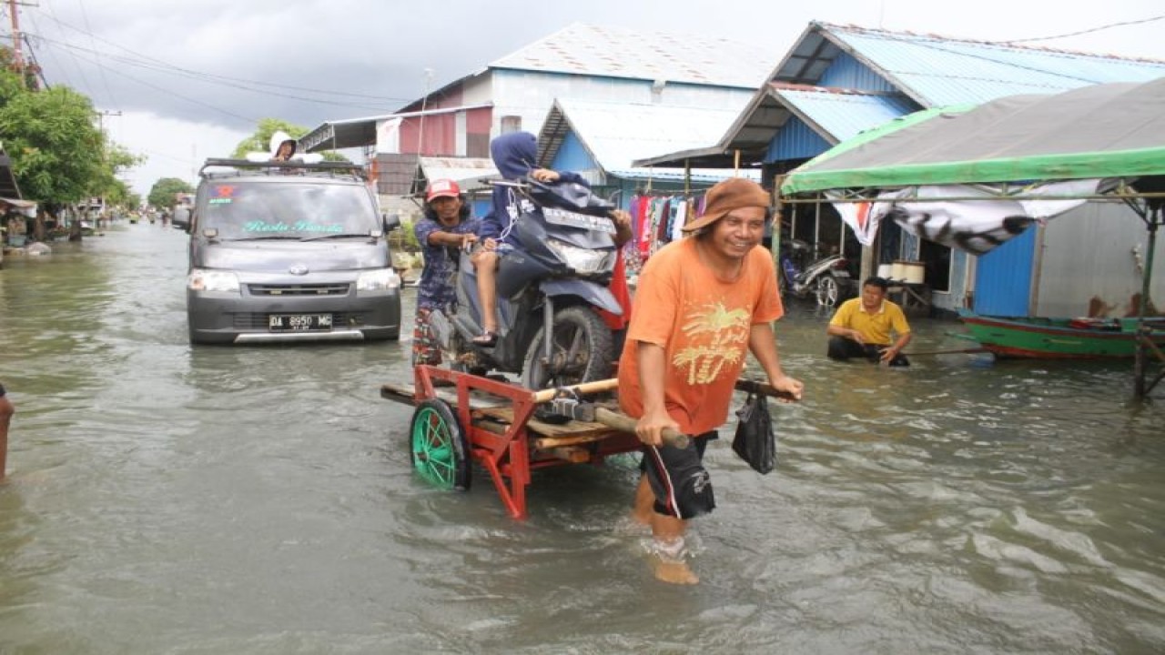 Warga memberikan jasa angkut sepeda motor saat melintasi jalan yang terendam banjir di Desa Sungai Rangas Ulu, Kabupaten Banjar, Kalimantan Selatan, Sabtu (4/3/2023). Berdasarkan data Pusdalops Badan Nasional Penanggulangan Bencana (BNPB) mencatat sebanyak 1.826 Kepala Keluarga atau 6.440 jiwa terdampak banjir di enam Kecamatan di Kabupaten Banjar. ANTARA/Bayu Pratama S.