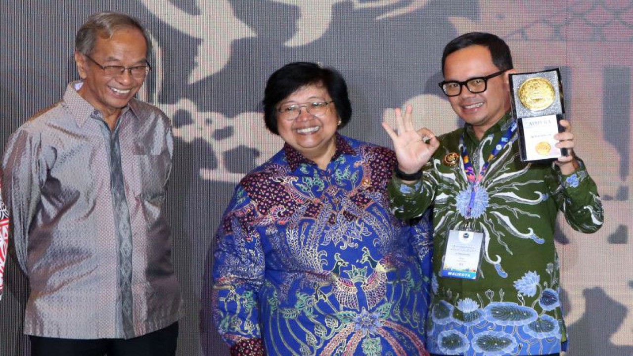 Menteri Lingkungan Hidup dan Kehutanan (LHK) Siti Nurbaya Bakar (tengah) bersama mantan Menteri Lingkungan Hidup Sarwono Kusumaatmadja (kiri) menyerahkan Piala Adipura 2022 kepada Wali Kota Bogor Bima Arya (kanan) di Gedung Manggala Wanabakti, Jakarta, Selasa (28/2/2023).ANTARA FOTO / Irwansyah Putra/rwa. (ANTARA FOTO/IRWANSYAH PUTRA)