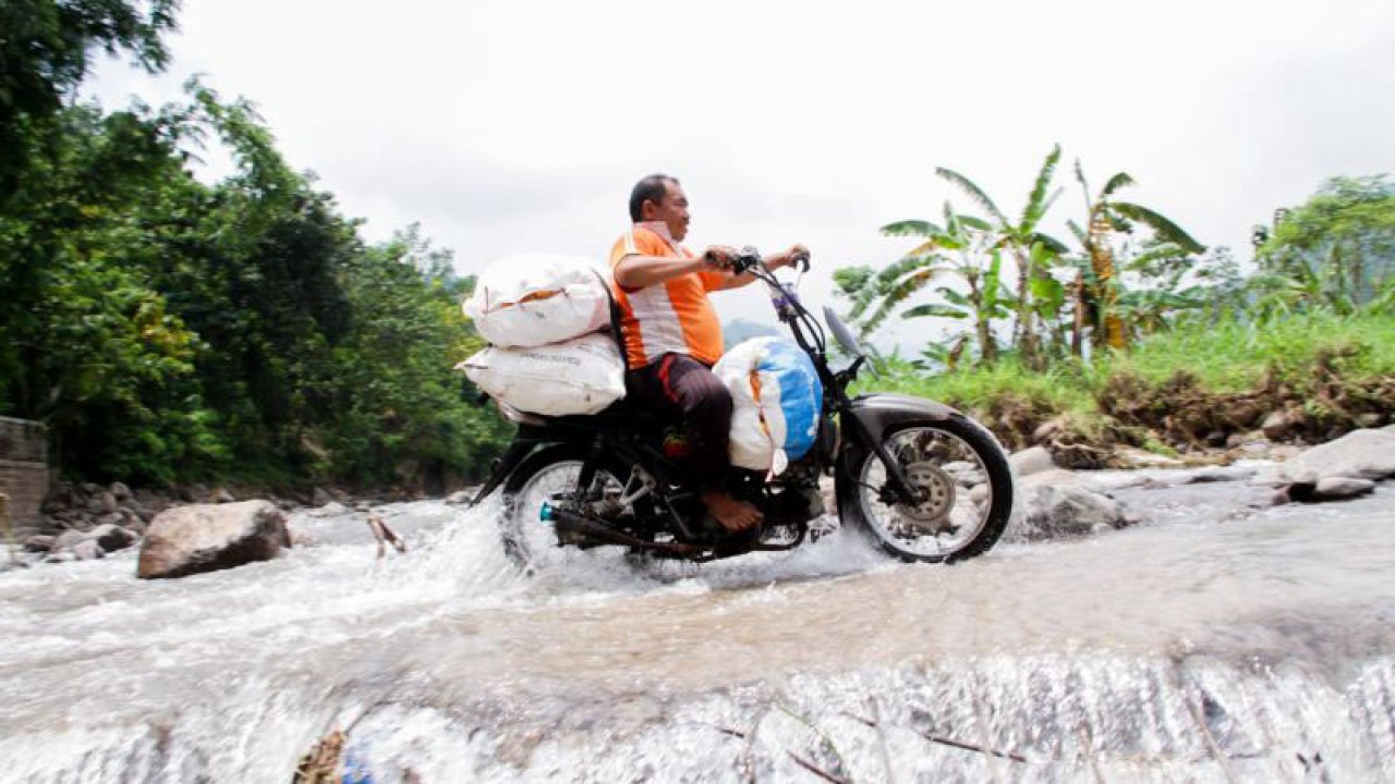 Pengendara sepeda motor warga Desa Patemon, Kecamatan Jatibanteng, Situbondo, melintas di jembatan limpas yang tidak berfungsi normal akibat banjir. Senin (6/3/2023) ANTARA/Novi Husdinariyanto