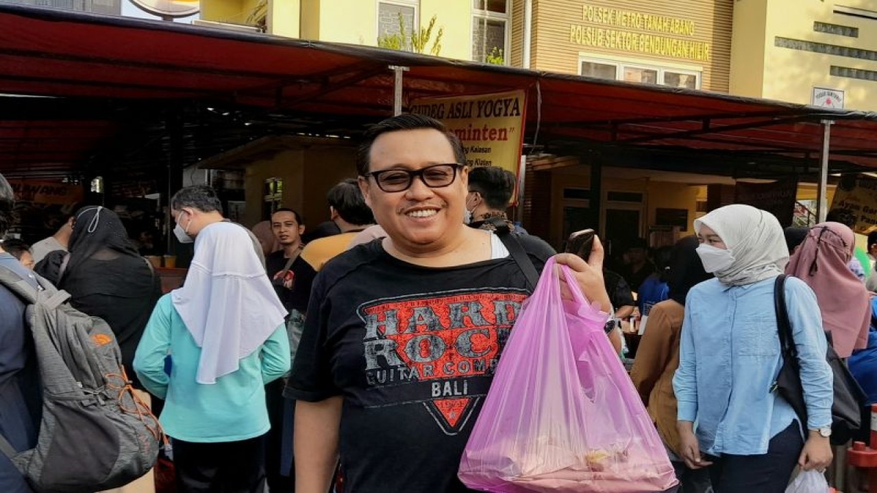 Bambang Susanto (53) pengunjung pasar takjil Benhil membawa ikan bakar favoritnya saat ditemui di Jakarta, Kamis (23/3/2023). (ANTARA/Lintang Budiyanti Prameswari)