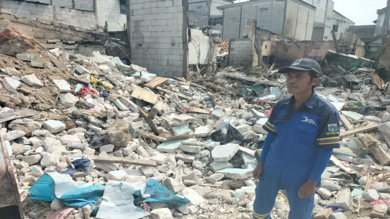 Petugas SDA Kecamatan Koja, Jakarta Utara, Imam (51) di atas puing rumah yang terbakar di Jalan Tanah Merah Bawah, Koja, Jakarta Utara, Senin (6/3/2023) (ANTARA / Walda)