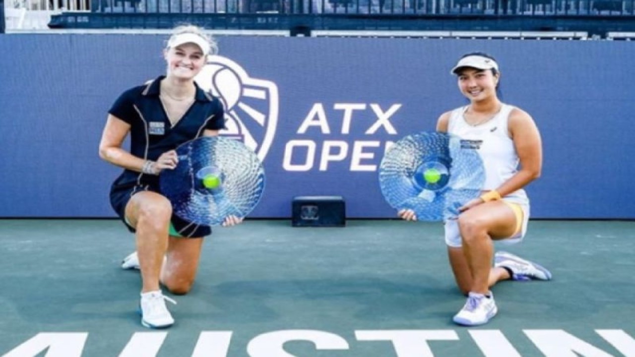 Petenis putri Indonesia Aldila Sutjiadi (kanan) yang berpasangan dengan petenis Selandia Baru Erin Routliffe (kiri) memamerkan trofi kemenangan usai menjuarai ATX Open di Austin, Amerika Serikat, Senin (6/3/2023). (ANTARA/HO-ATXOPEN)