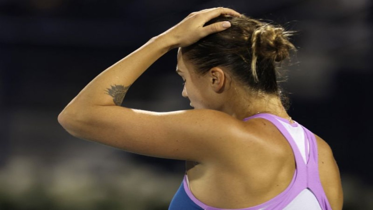 Petenis Belarus Aryna Sabalenka bereaksi saat berhadapan dengan Barbora Krejcikova dalam perempat ifnal turnamen WTA di Dubai. (23/12/2023) (AFP/KARIM SAHIB)