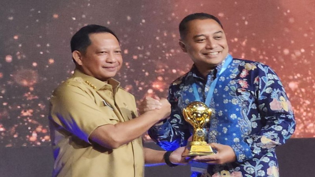 Menteri Dalam Negeri Tito Karnavian menyerahkan penghargaan kepada Wali Kota Surabaya Eri Cahyadi dalam acara UHC Award di Balai Sudirman, Tebet, Jakarta Selatan, Selasa (14/3/2023). (FOTO ANTARA/HO-Diskominfo Surabaya)
