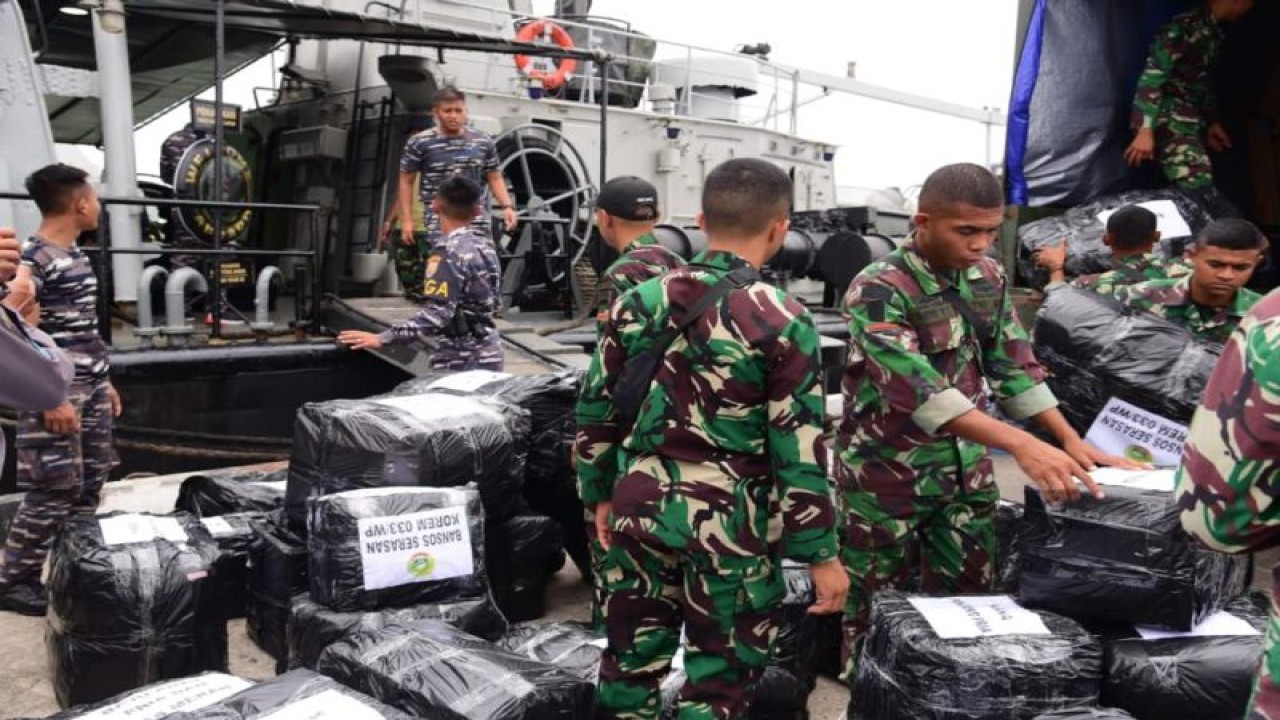 Prajurit TNI AL memindahkan bantuan sosial ke atas KRI Silas Papare-386 untuk dikirim kepada masyarakat terdampak bencana banjir dan longsor di Serasan, Natuna, Kepri, Senin (13/3/2023). (ANTARA/HO-Dispen Koarmada I)