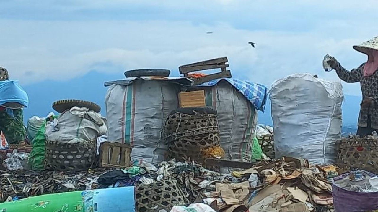 Seorang ibu mengumpulkan sampah botol plastik kemasan di Tempat Pembuangan Akhir (TPA) Kebon Kongok, Kabupaten Lombok Barat, NTB. (ANTARA/Awaludin)