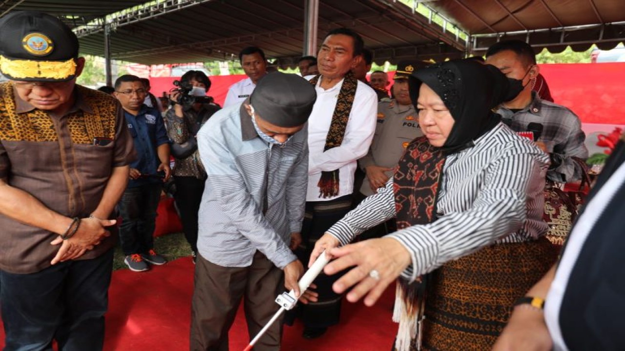 Menteri Sosial Tri Rismaharini membantu penyandang disabilitas menggunakan tongkat penuntun adaptif dalam kunjungan kerjanya ke Kabupaten Ende, NTT, Selasa (28/2/2023). (ANTARA/HO-Kemensos RI)
