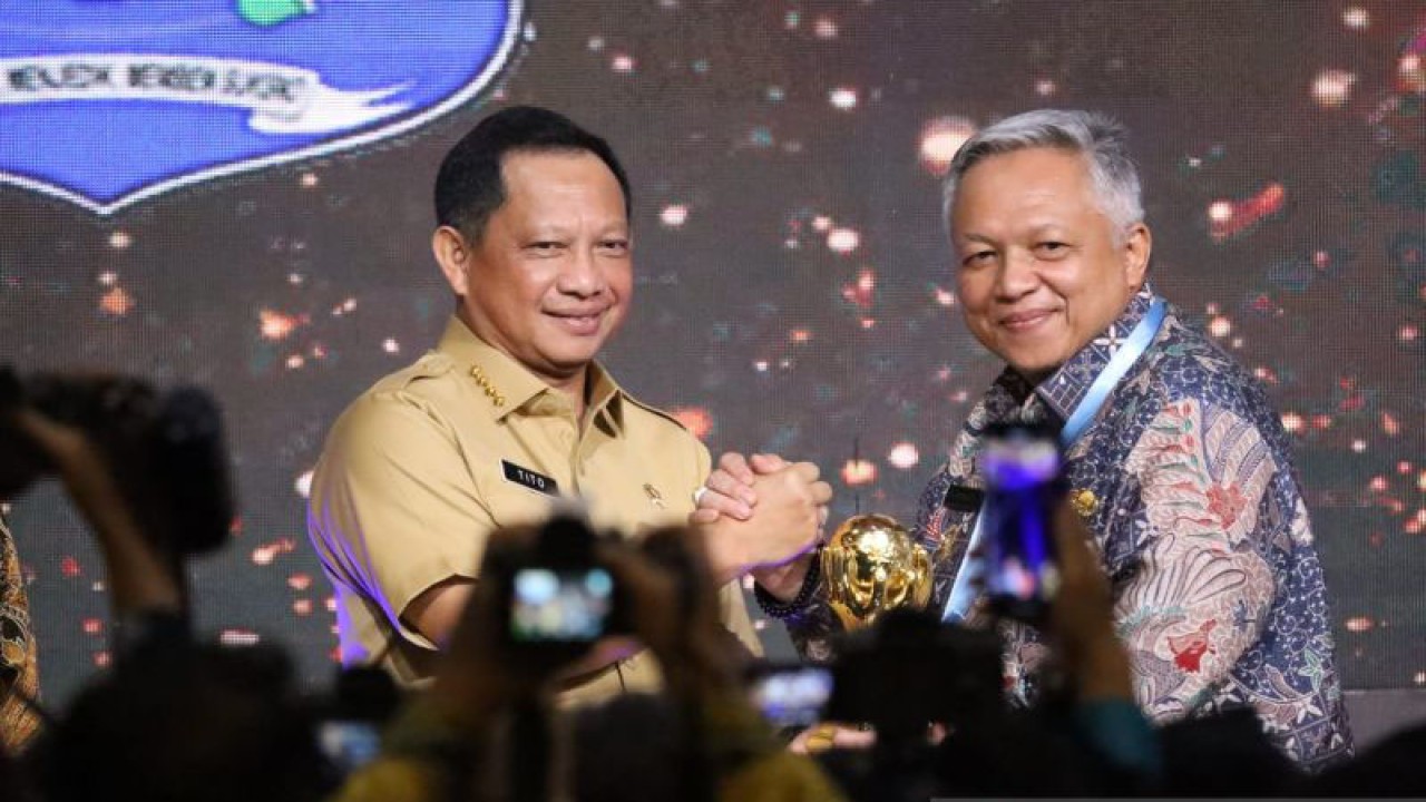 Bupati Bangka Barat Sukirman (kanan) menerima penghargaan UHC dari Menteri Dalam Negeri Tito Karnavian di Jakarta, Selasa (14/3/2023). (ANTARA/HO-Diskominfo Kabupaten Bangka Barat)