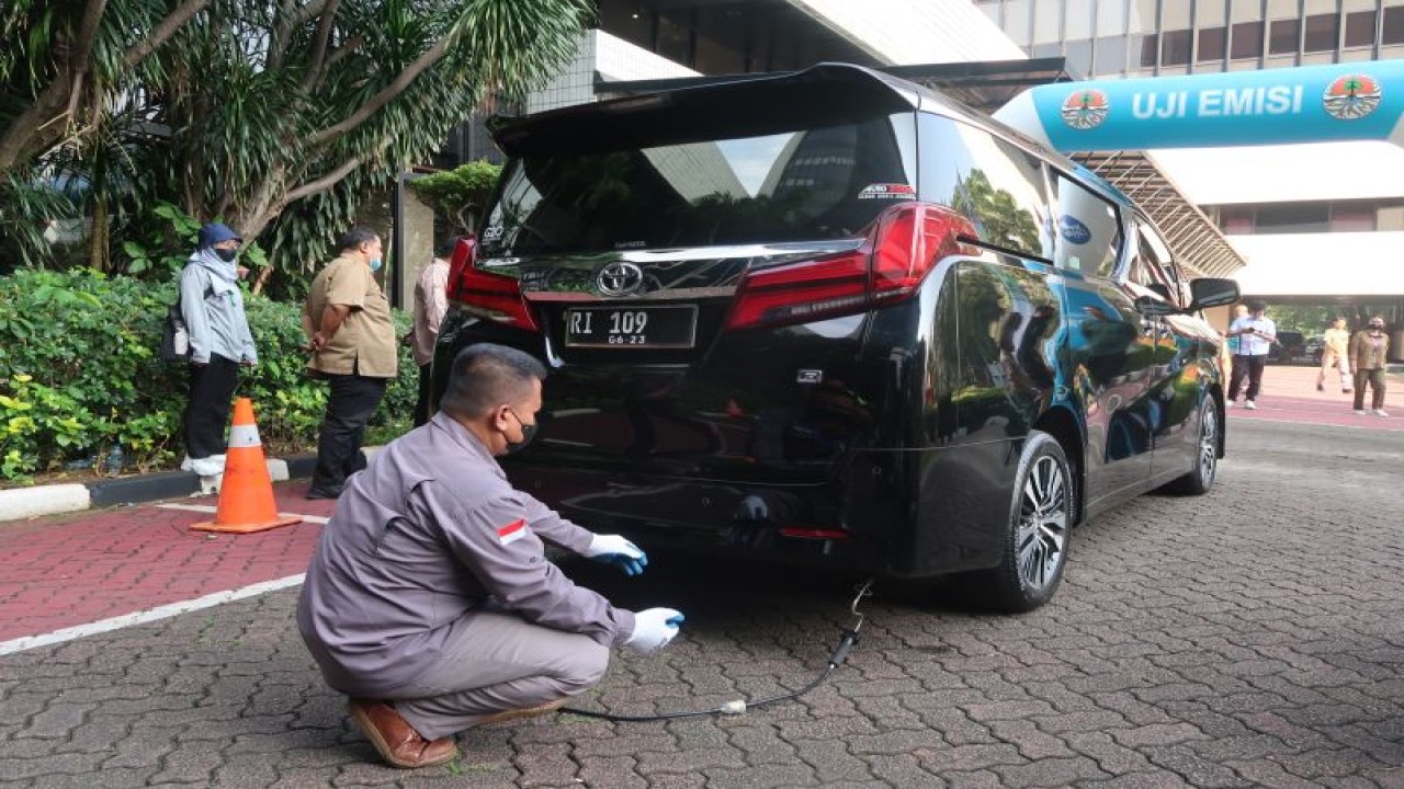 Seorang petugas melakukan uji emisi terhadap kendaraan bermotor di teras samping auditorium Gedung Manggala Wanabakti Kementerian LHK, Jakarta Pusat, Selasa (21/3/2023). (ANTARA/Sugiharto Purnama)