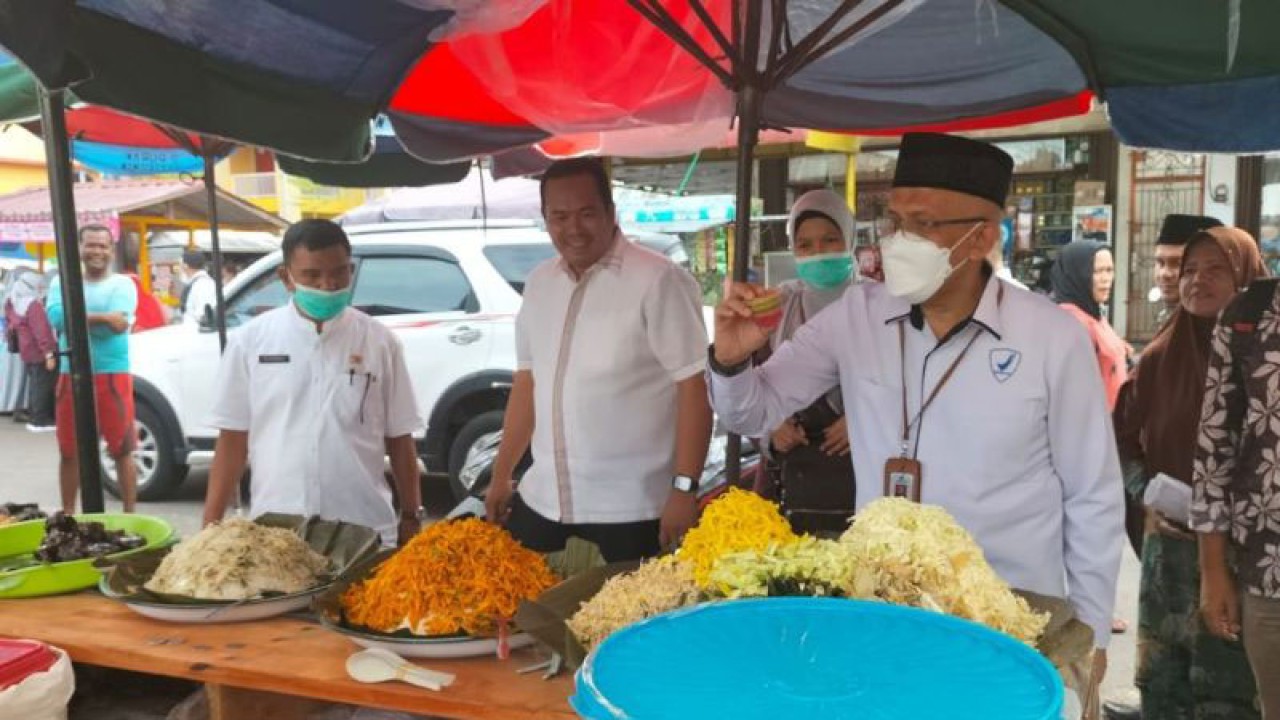 Kepala Dinas Perindustrian Perdagangan Koperasi dan UKM Kota Pariaman, Sumbar Alyendra (kiri) melihat pengambilan sampel takjil oleh Kepala BPOM di Padang, Sumbar Abdul Rahim (kanan) di Pasar Pabukoan di Pariaman pata 2022. (ANTARA/Aadiaat M. S.)