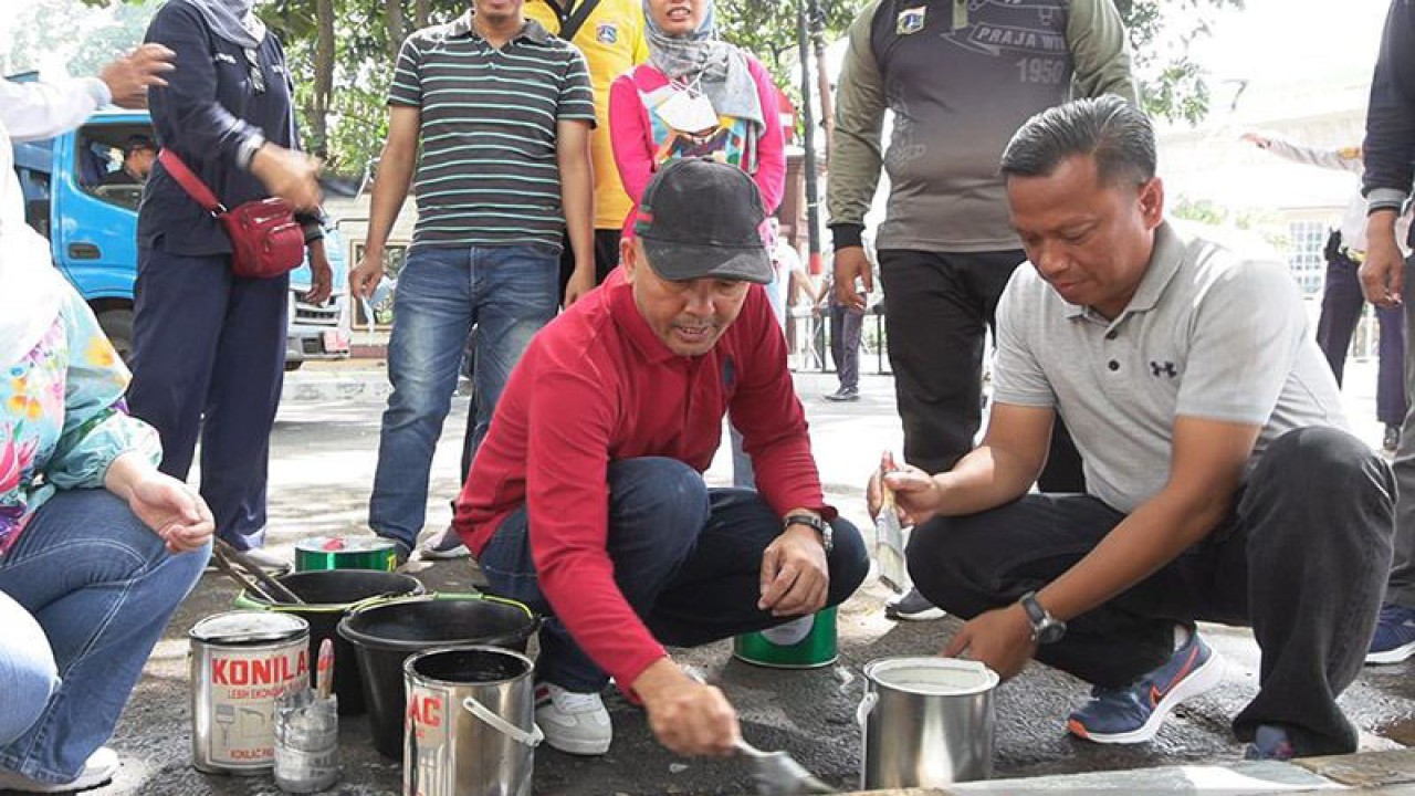Wali Kota Administrasi Jakarta Selatan Munjirin mengecat pembatas trotoar (kanstin) di Jalan Trunojoyo, dekat Gedung Sekretariat ASEAN menjelang Persiapan Rencana Pelaksanaan KTT organisasi itu di Jakarta pada 2023, Jakarta, Minggu (15/1/2023). ANTARA/HO-Kominfotik Jakarta Selatan/aa.