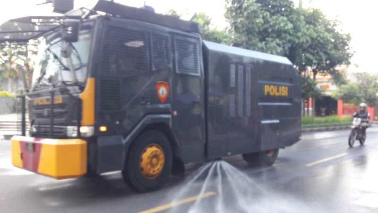 Polres Temanggung semprotkan air dengan mobil water cannon untuk menghilangkan abu Merapi di jalan. ANTARA/Heru Suyitno