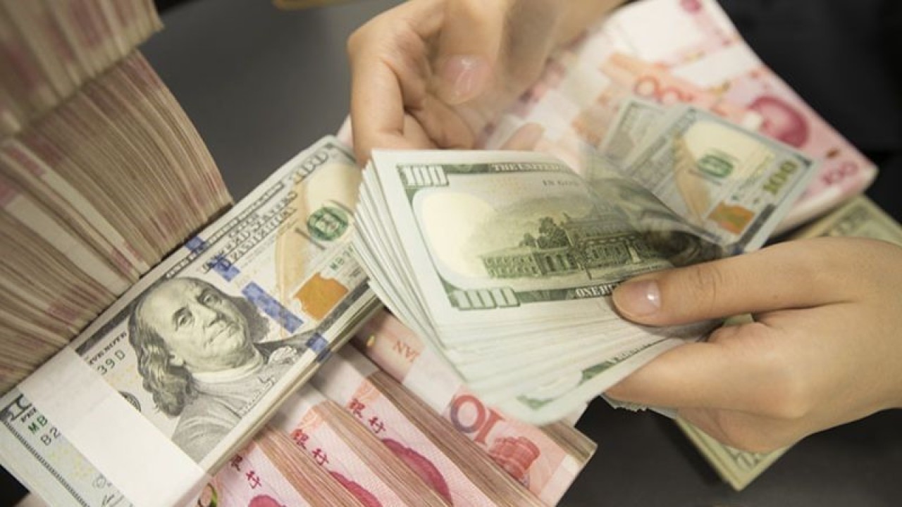 Arsip foto - Seorang pegawai Tiongkok menghitung uang kertas dolar AS di atas uang kertas yuan RMB (renminbi) di sebuah bank di kota Hai'an, kota Nantong, provinsi Jiangsu, Tiongkok timur, 6 Agustus 2019. ANTARA/Oriental Image via Reuters Connect-Xu jingbai/pri.