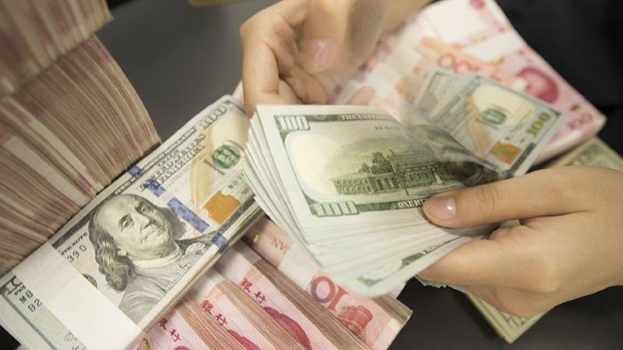 Arsip foto - Seorang pegawai Tiongkok menghitung uang kertas dolar AS di atas uang kertas yuan RMB (renminbi) di sebuah bank di kota Hai'an, kota Nantong, provinsi Jiangsu, Tiongkok timur, 6 Agustus 2019. ANTARA/Oriental Image via Reuters Connect-Xu jingbai/pri.