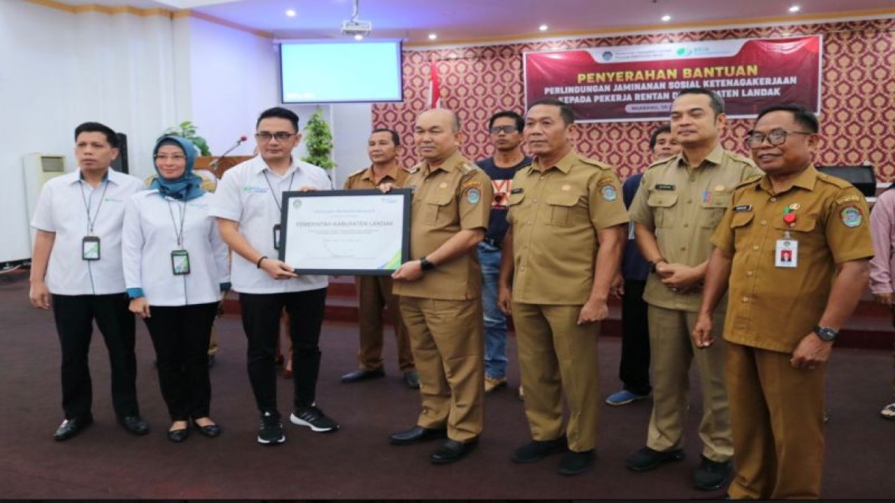 Pj. Bupati Landak Samuel menyerahkan secara simbolis bantuan kepesertaan program BPJAMSOSTEK untuk masyarakatnya. (ANTARA/Arif)