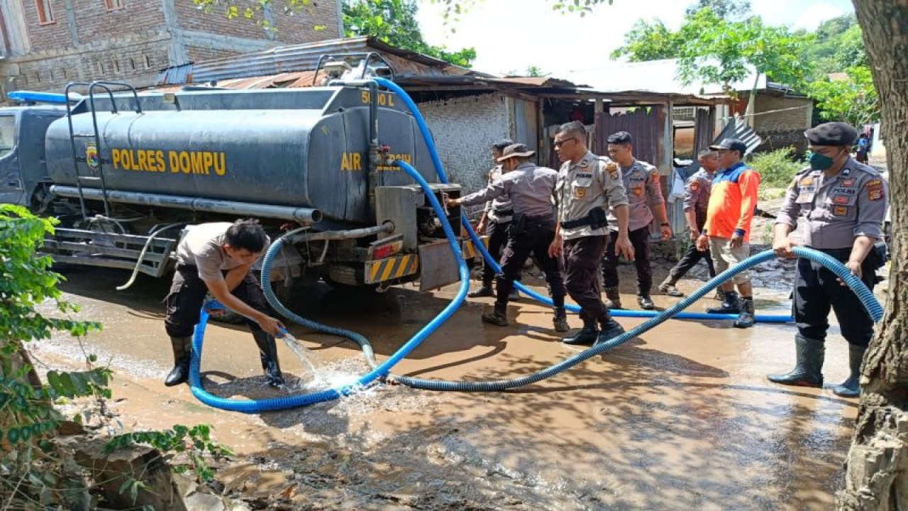 Anggota saat membersihkan lumpur bekas banjir di wilayah Dompu, NTB (ANTARA/Humas Polres Dompu)