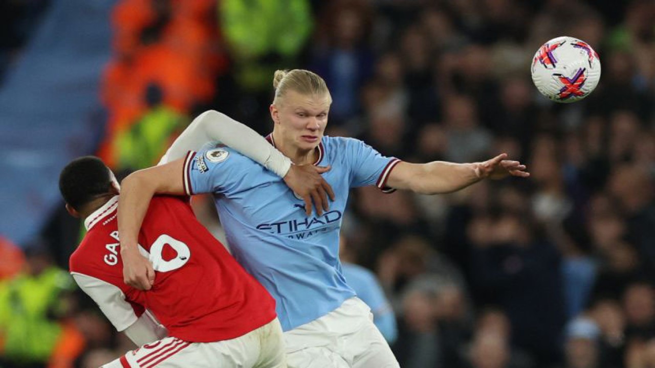 Pesepak bola Manchester City Erling Haaland melewati pemain Arsenal Gabriel dalam laga lanjutan Liga Inggris di Etihad Stadium, Manchester, Inggris, Rabu (26/4/2023). City menang dengan skor 4-1. ANTARA FOTO/REUTERS/Phil Noble/foc.