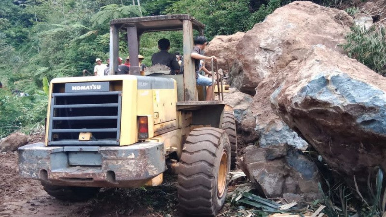 Petugas membersihkan longsoran batu besar yang menutupi bagian jalan di Jalur Bandung-Garut di wilayah Kecamatan Talegong, Kabupaten Garut, Provinsi Jawa Barat, Rabu (12/4/2023). (ANTARA/HO-Polres Garut)