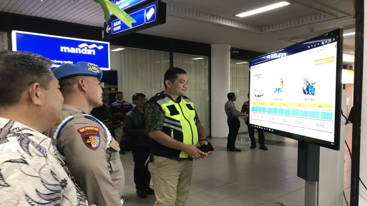 Kepala Posko Angkutan Lebaran Bandara Internasional Batam Khoufan Rizki Oktarian (rompi hijau) melihat monitor pengawas di Posko Angkutan Lebaran, Jumat (14/4). (ANTARA/Yude)
